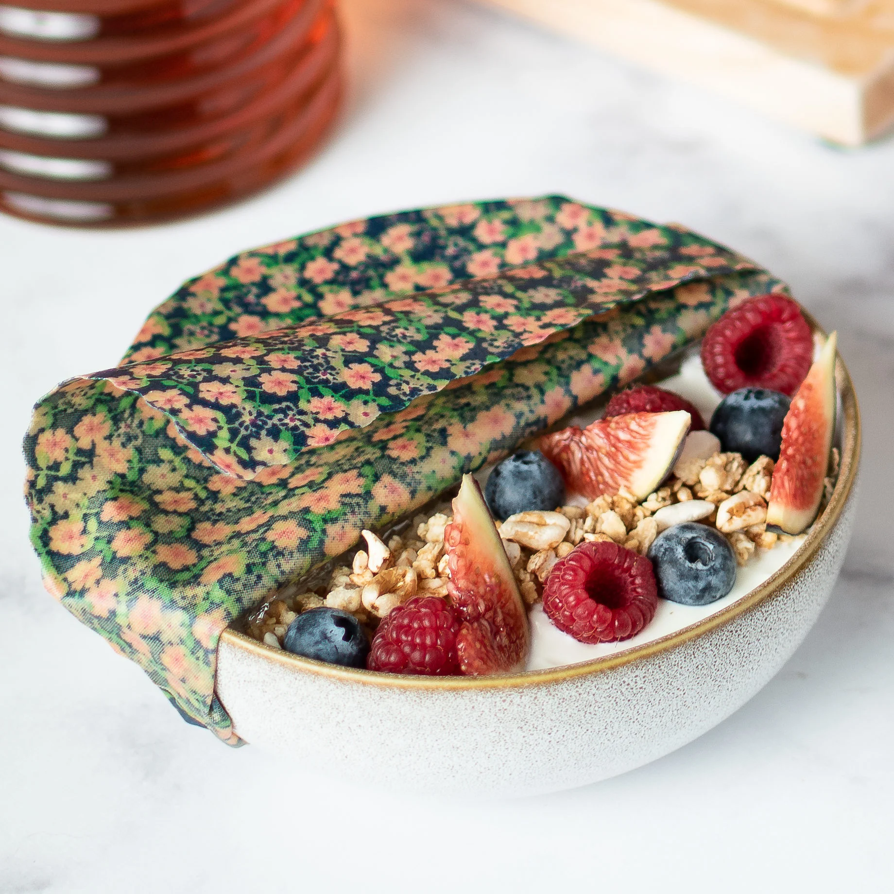 Bee wrap taille Small collection "Fleurs des champs" de L'abeille qui emballe, couvrant un bol de fromage blanc et fruits au petit déjeuner