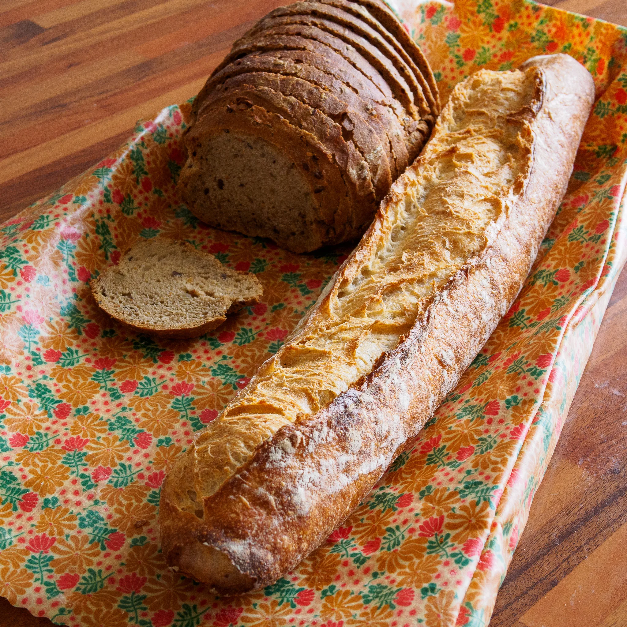 Sac à pain en cire d'abeille avec une baguette et un pain tranché
