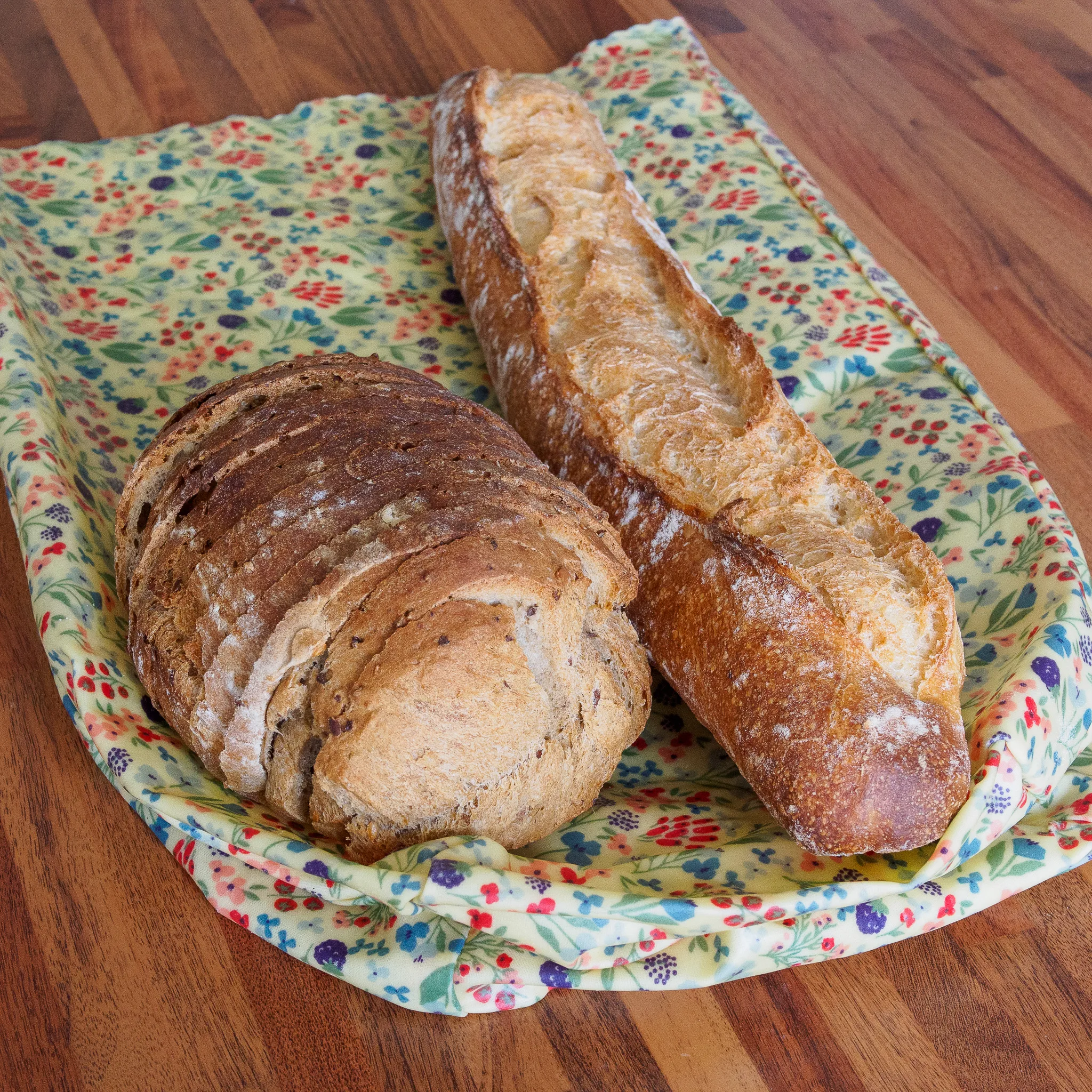 Sac à pain en cire d'abeille avec une baguette et un pain tranché